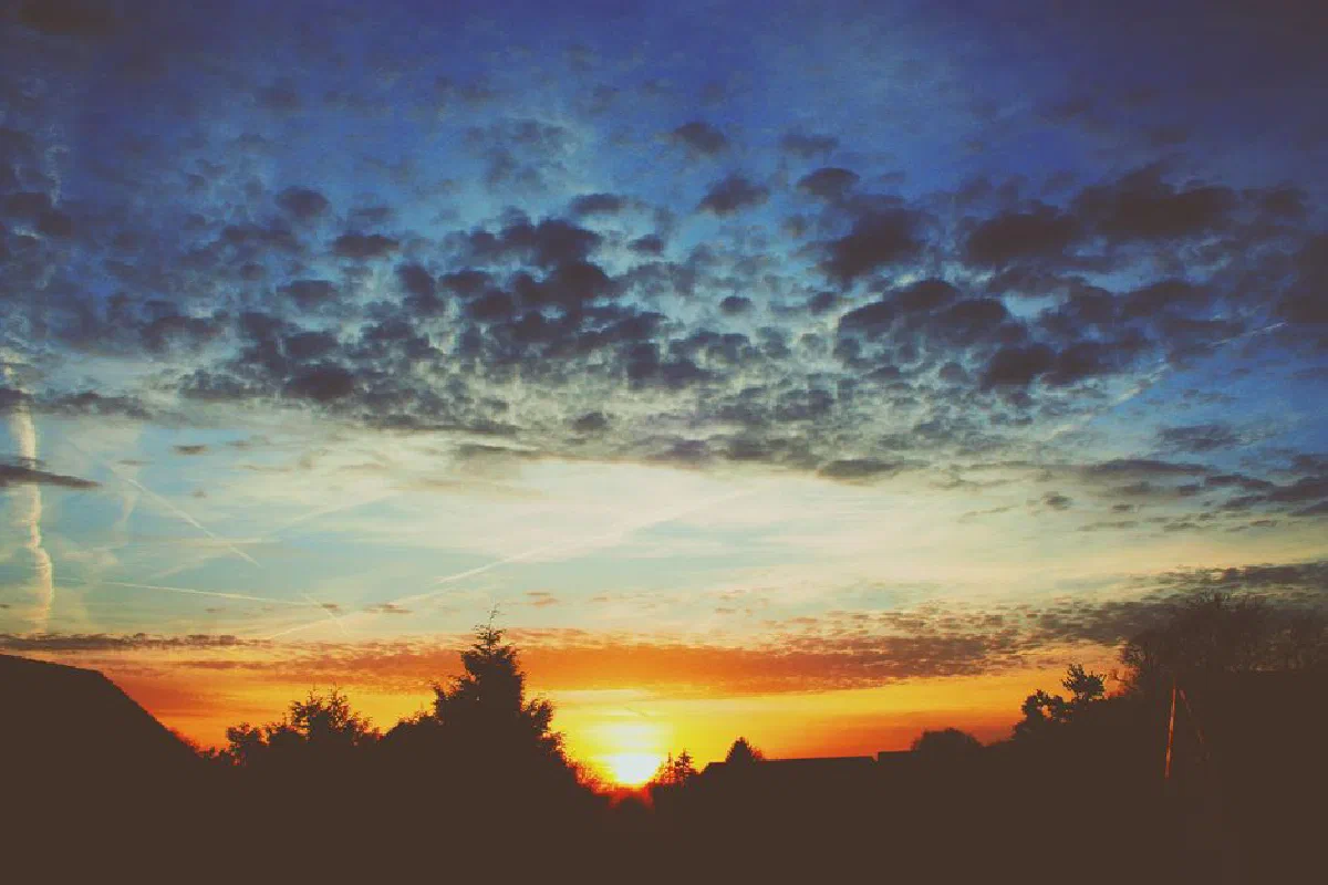 A vibrant sunset with dramatic clouds over Emmen, Netherlands, capturing the colors of nature.