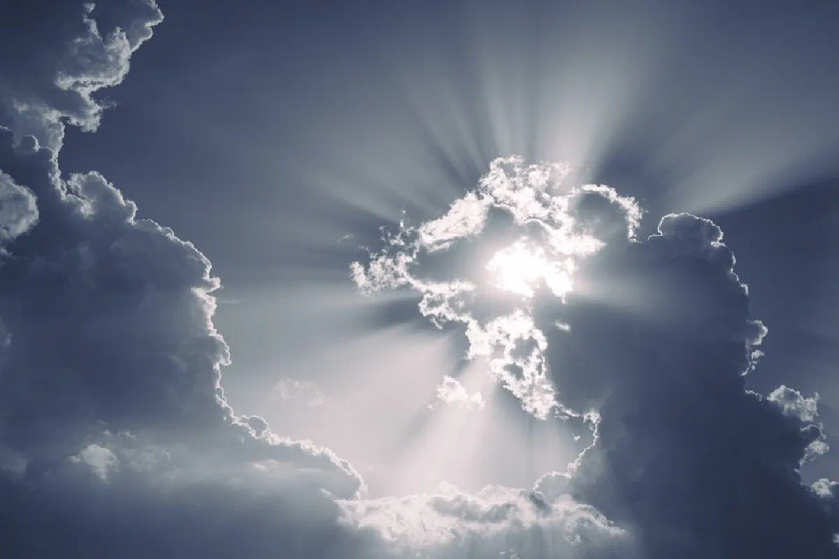 Sun rays piercing through dramatic clouds, creating a stunning atmospheric effect.
