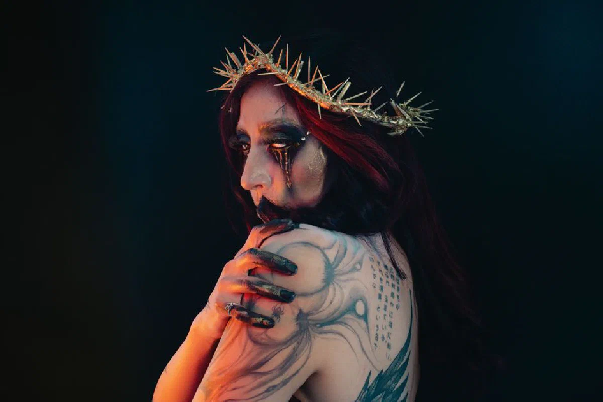 Creative portrait featuring a woman in a gothic costume and intricate tattoos.