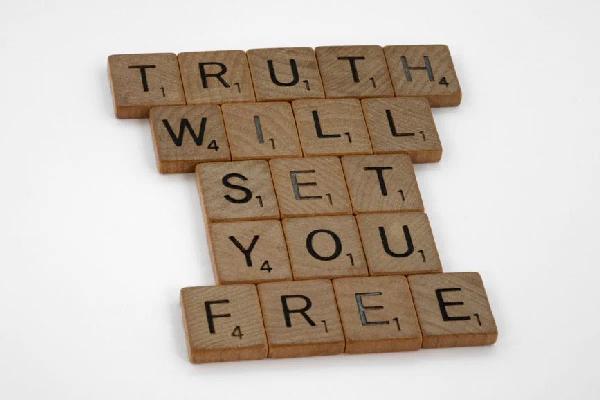 Scrabble tiles forming the phrase 'Truth Will Set You Free' on a white surface.