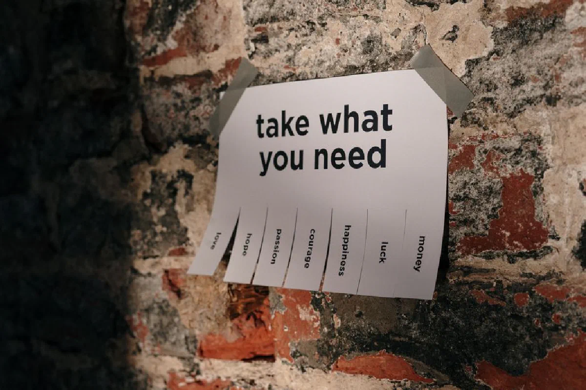 A motivational note offering positive qualities taped to a brick wall.