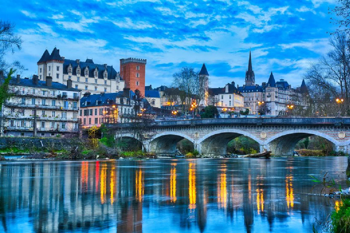 Captivating twilight scene of Pau, France, featuring the iconic Pau Castle and serene river reflections.