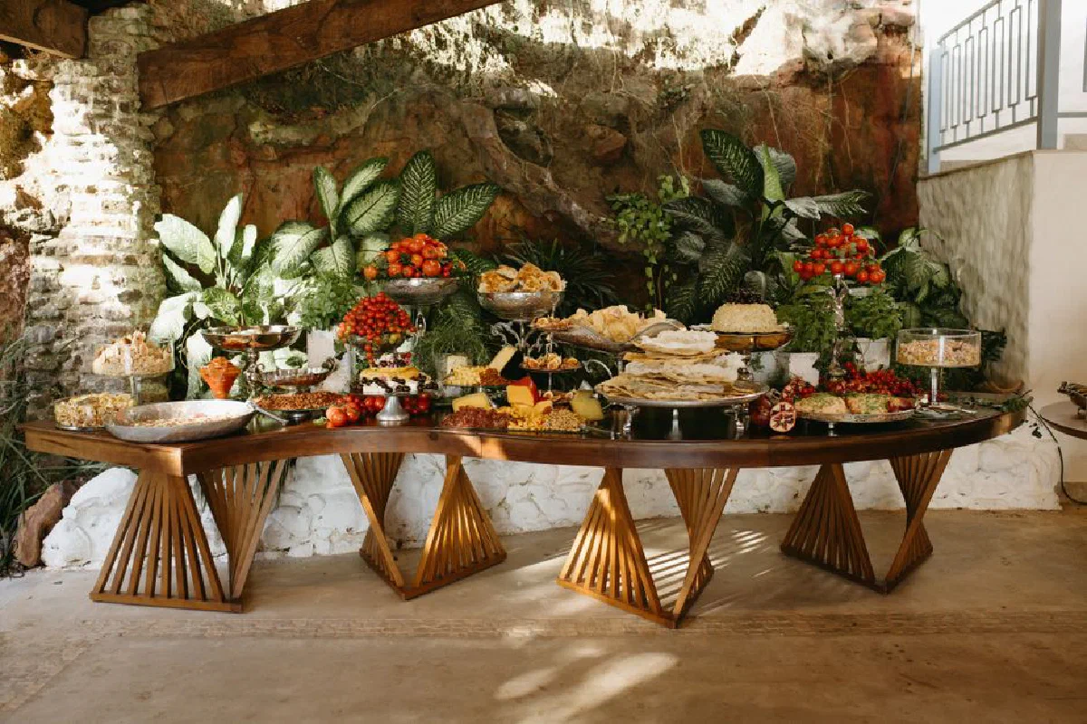 A lavish buffet table with assorted foods and vibrant greenery background.