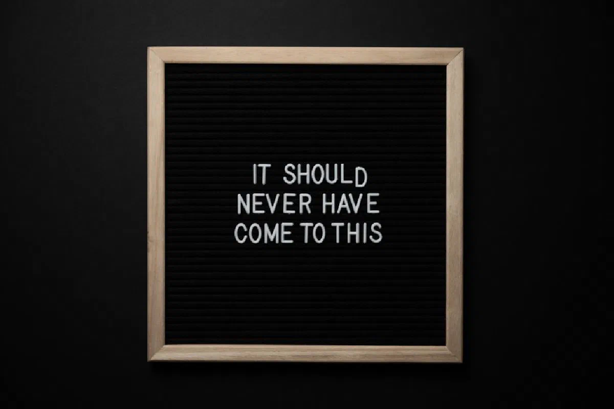 Top view of blackboard with IT SHOULD NEVER HAVE COME TO THIS inscription on black background