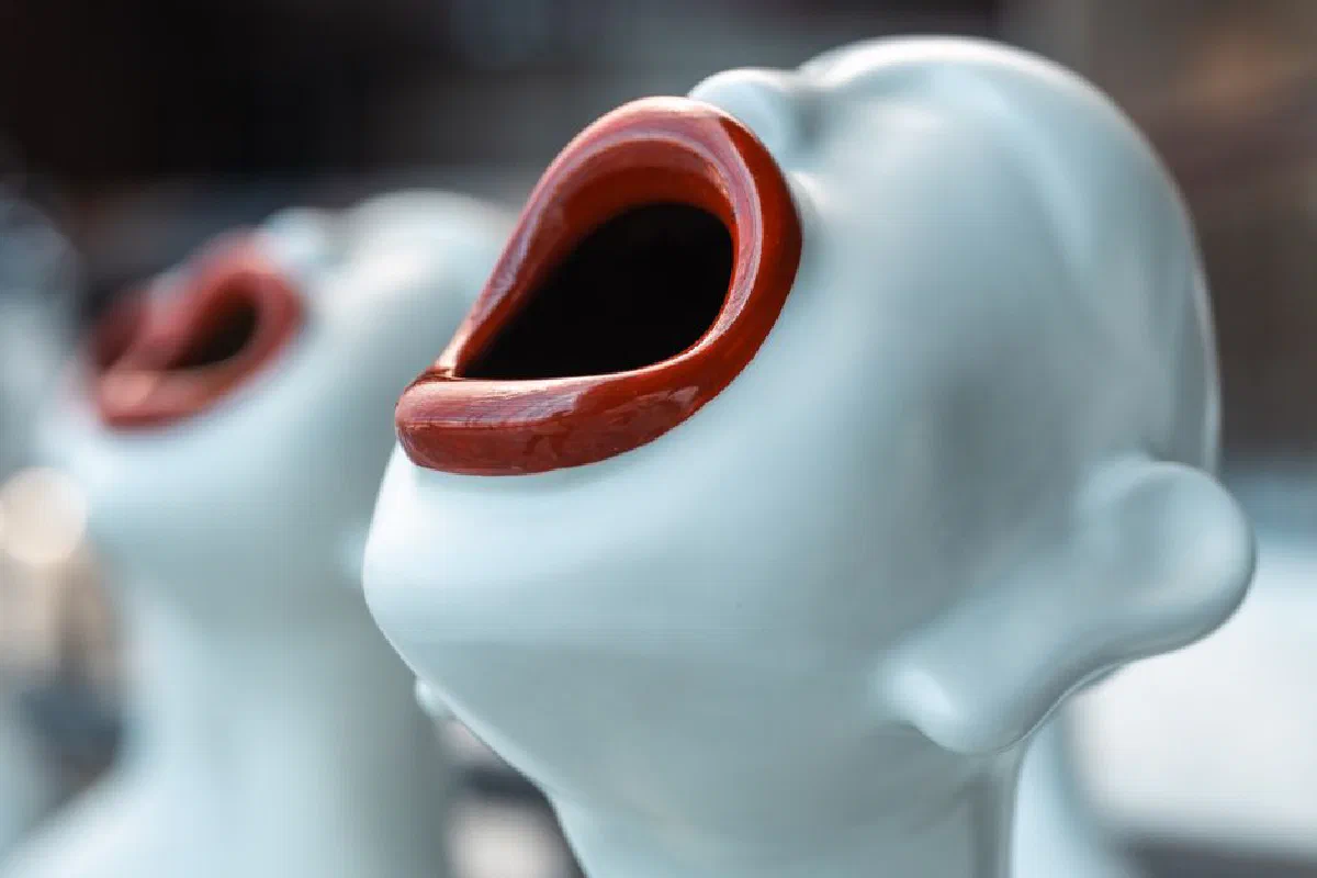 Close-up of abstract sculptures with red open mouths, creating a bold artistic statement.