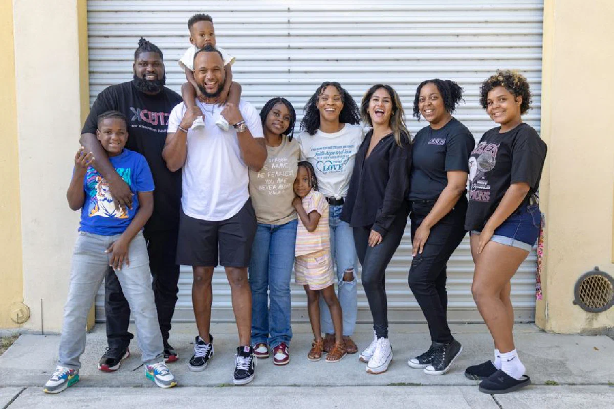 A joyful diverse family group posing together in front of a garage door, showcasing unity and happiness.