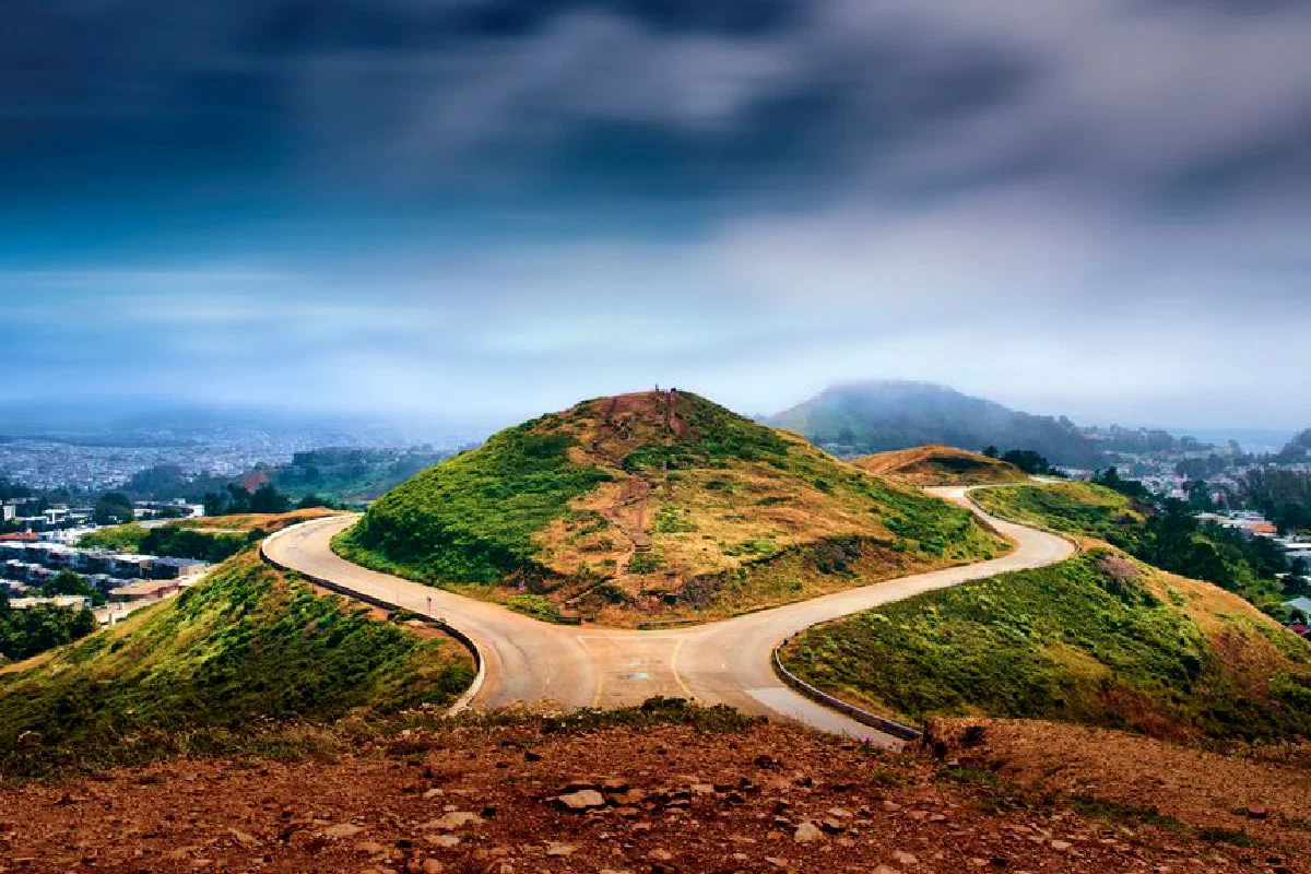 Breathtaking view of winding road at Twin Peaks overlooking San Francisco cityscape.