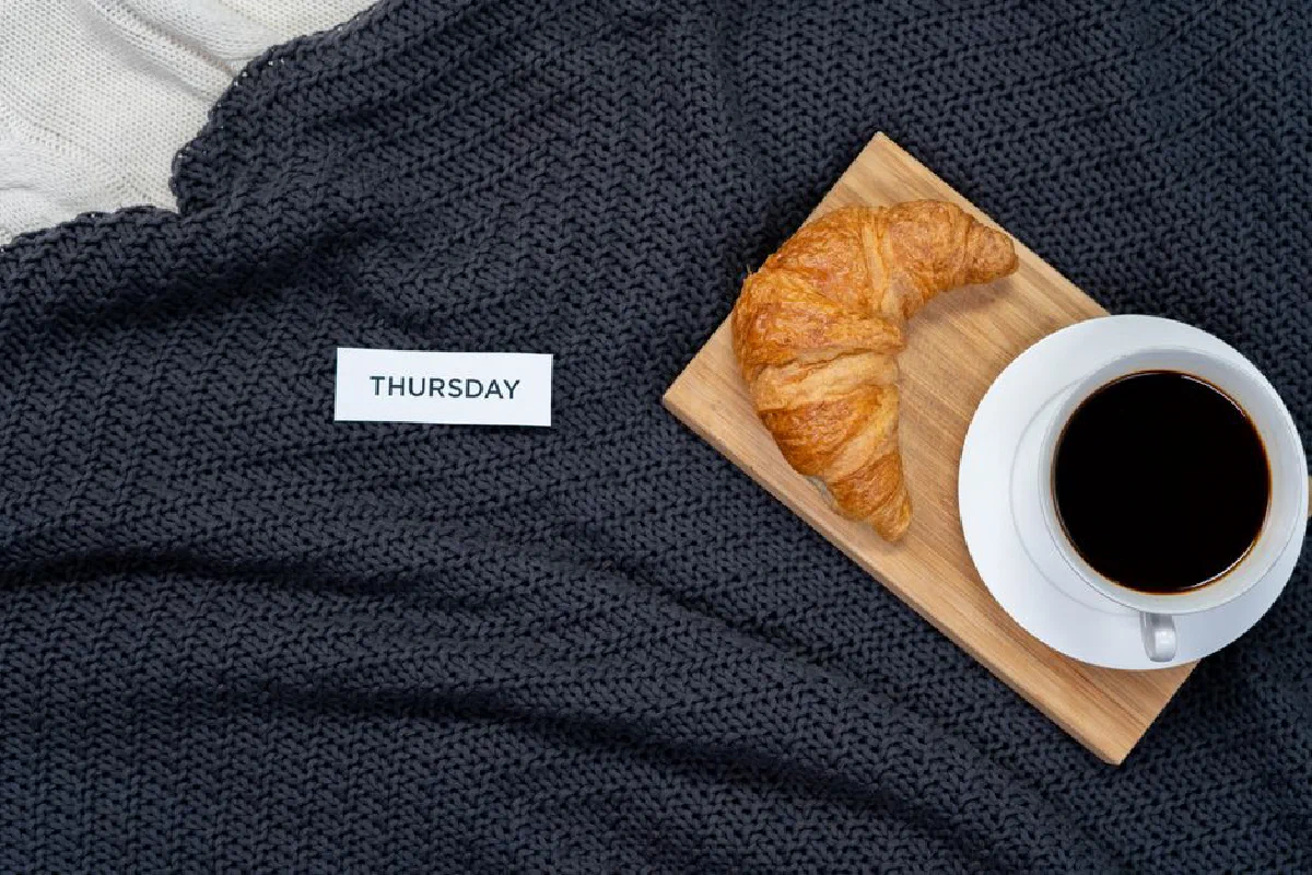 Start your day with a cozy breakfast of croissant and coffee on a warm blanket.