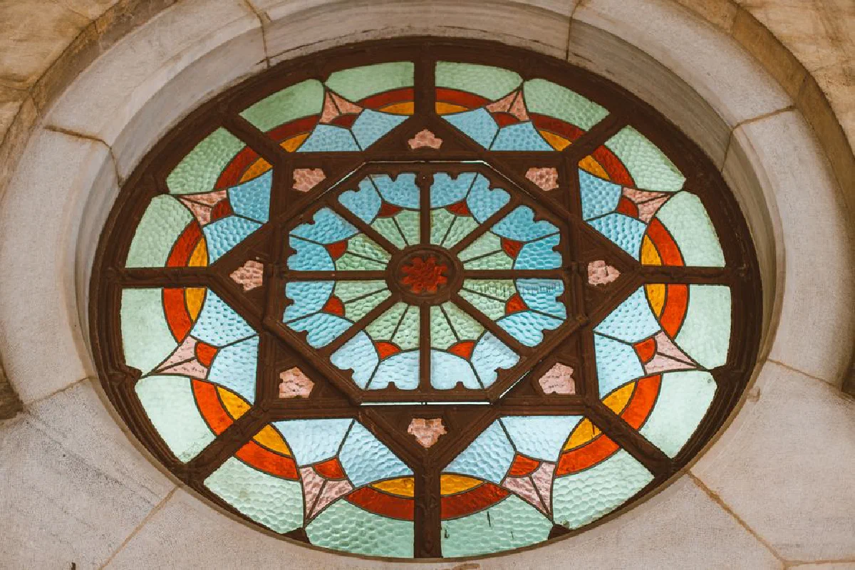 Intricate circular stained glass window featuring vibrant geometric patterns and vivid colors.
