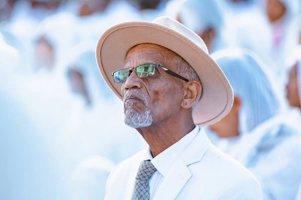 Elderly man in beige hat and white suit at a religious event in Addis Ababa, Ethiopia.