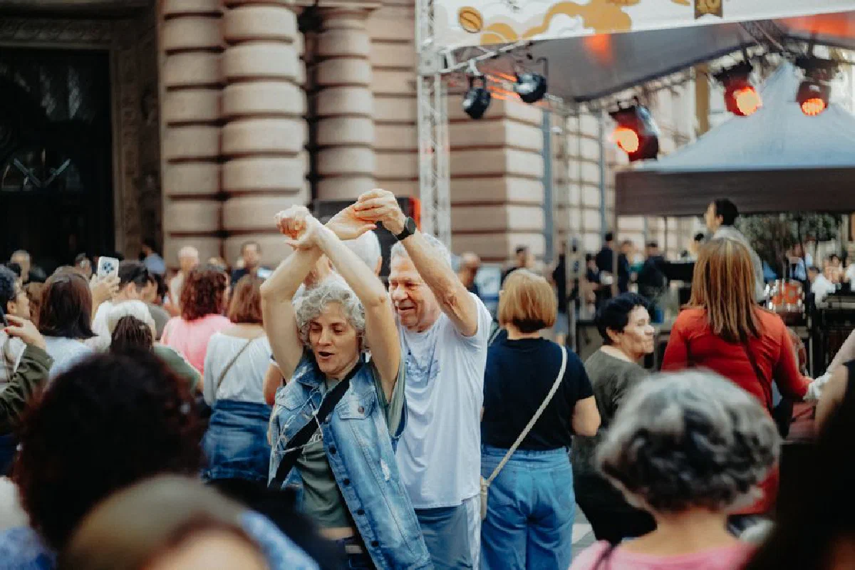 A vibrant street festival with people dancing and celebrating in a lively outdoor setting.