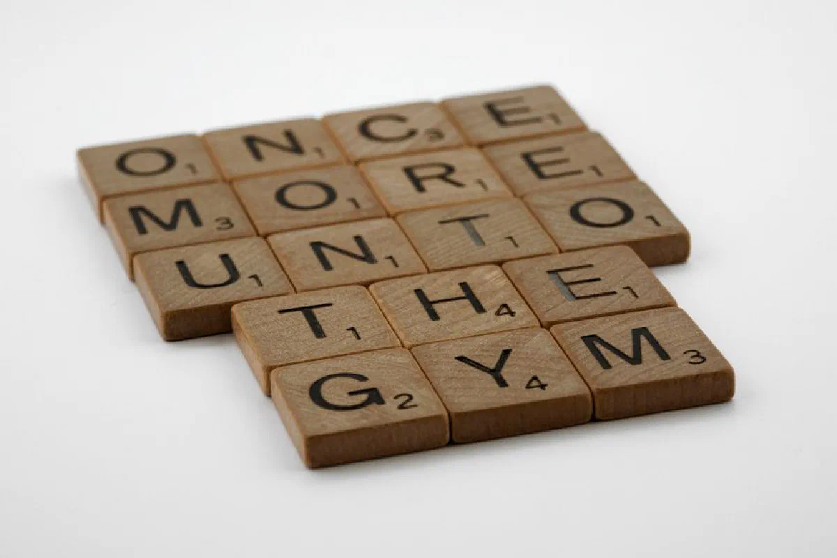 Scrabble tiles forming the motivational phrase 'Once More Unto the Gym' on a white background.