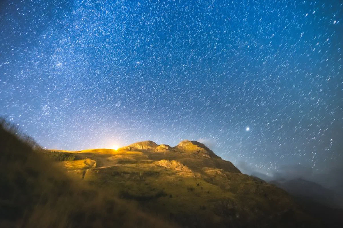 Capture of the starry night sky over the majestic Écrins National Park mountains in France.