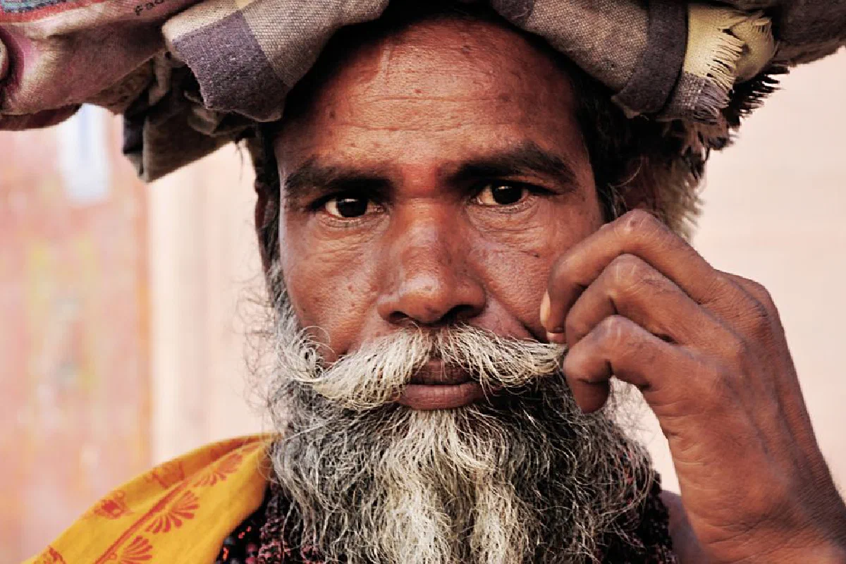 Close-up portrait of an elderly man with a beard and turban in Varanasi, India.