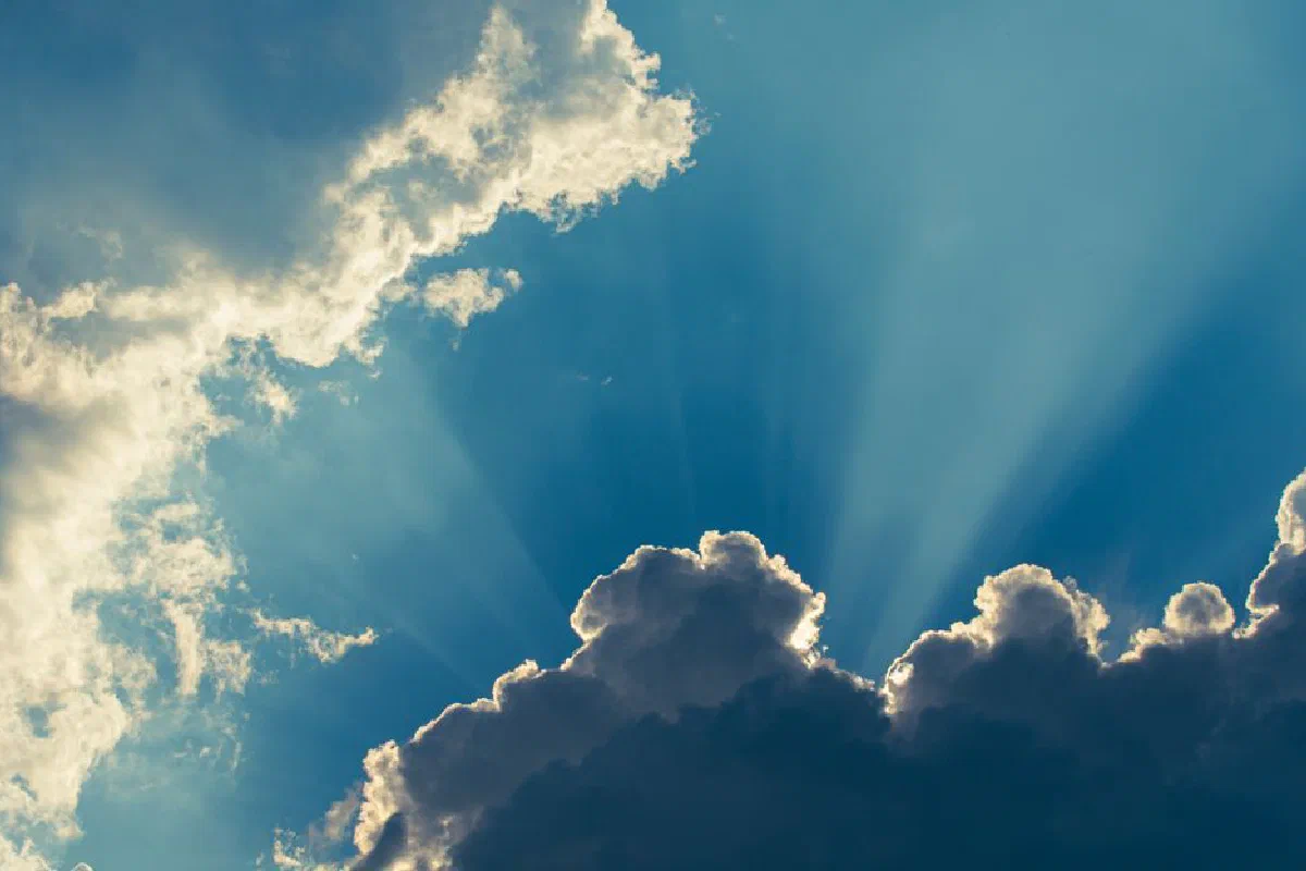 Captivating image of sun rays breaking through dense clouds creating a dramatic atmosphere.