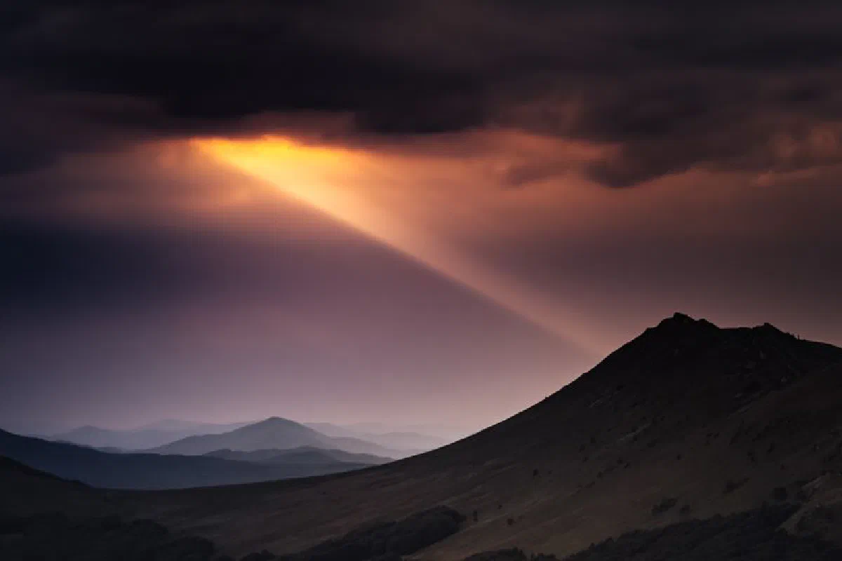 A stunning sunset with light beams over Bieszczady Mountains, Poland.