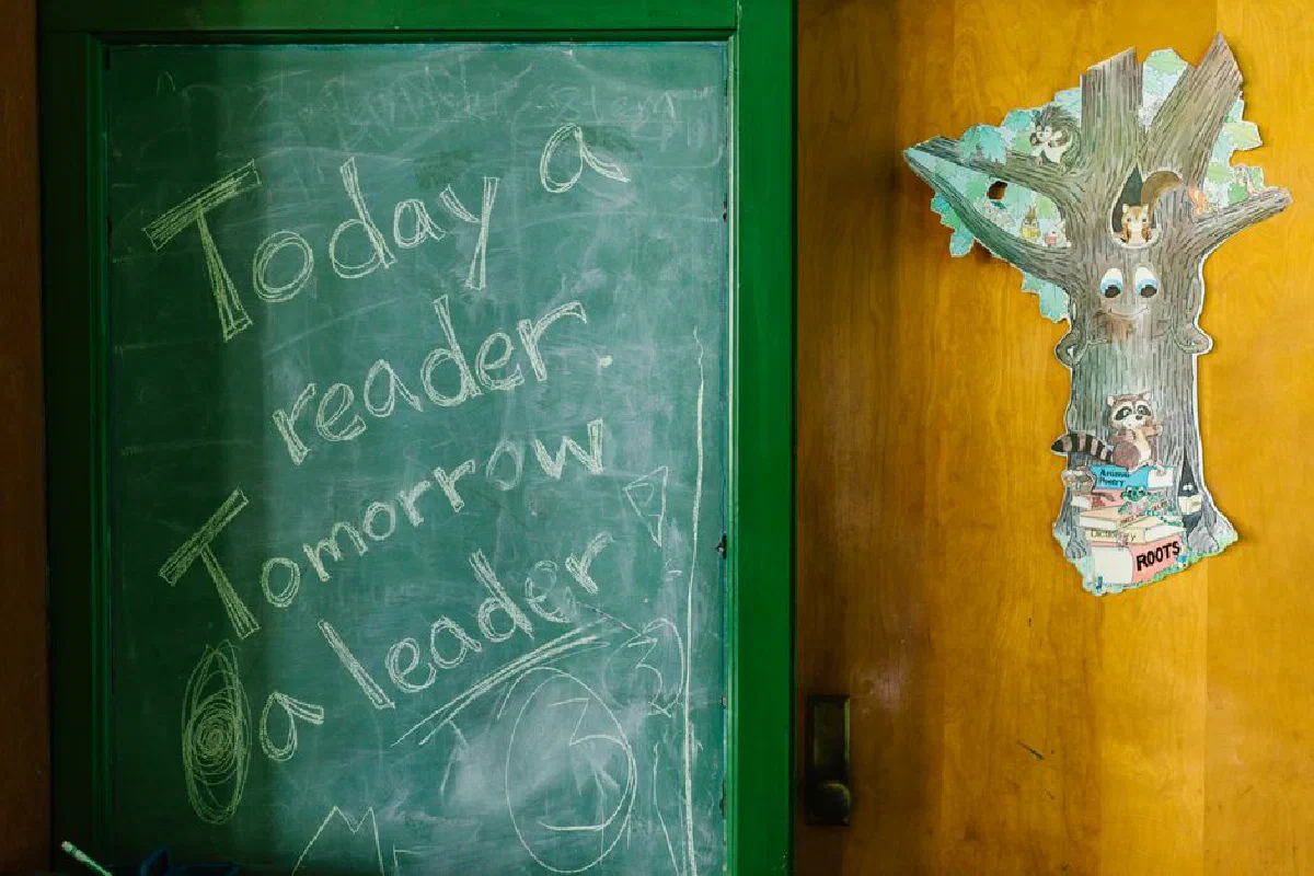 Motivational chalkboard message in a classroom with educational decor.