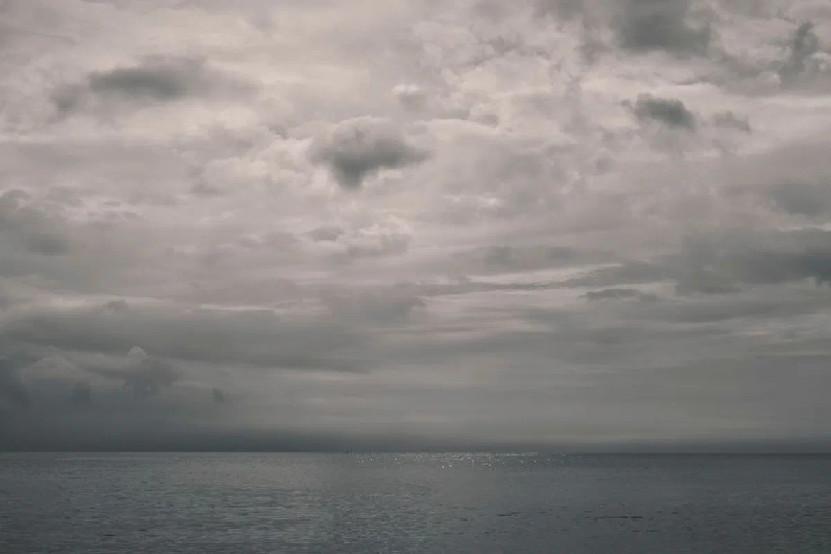 A peaceful yet dramatic seascape with an overcast sky, perfect for themes of serenity or contemplation.