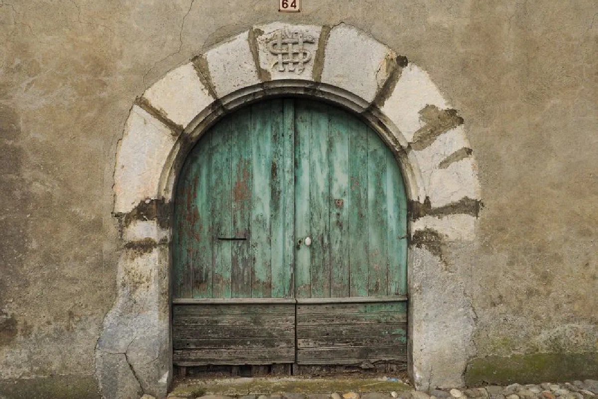 Rustic old wooden door set in stone archway, numbered 64. Perfect for architecture and history themes.