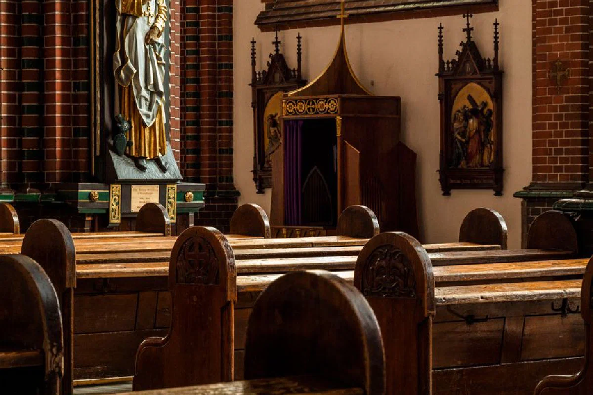 Elegant church interior featuring wooden pews and religious sculptures.