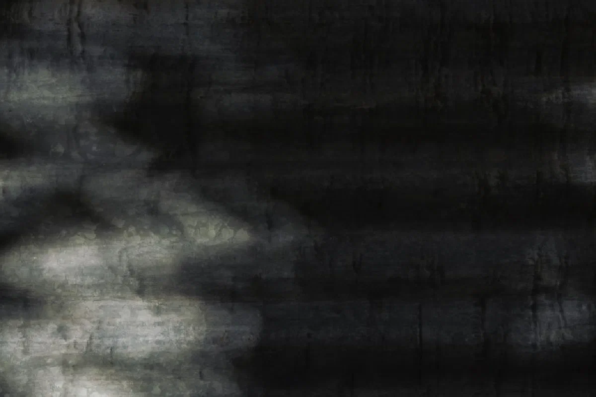 Close-up of a dark metal surface with abstract shadows and textures.