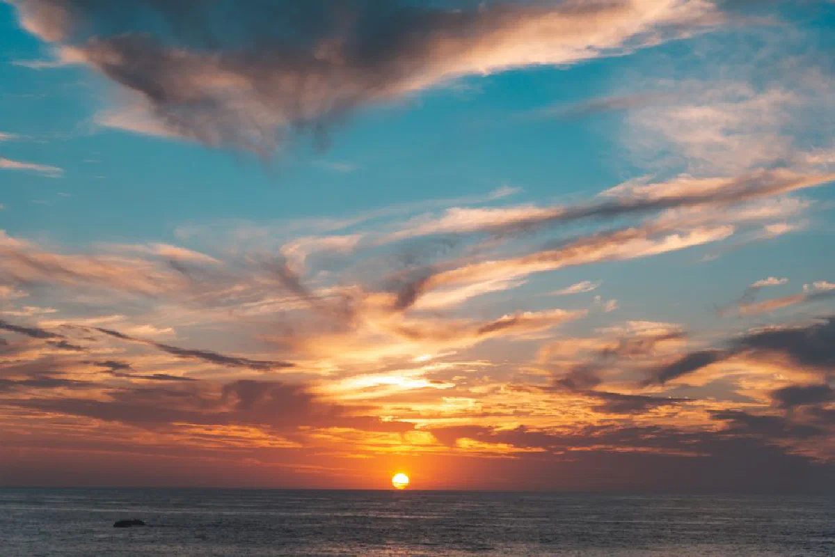 Stunning sunset over the ocean with vivid colors and dramatic clouds creating a mesmerizing scene.