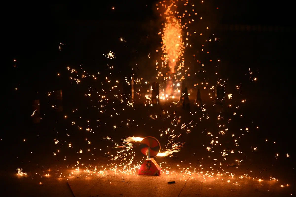 Long exposure shot of vibrant fireworks exploding at night, illuminating the sky with sparks.