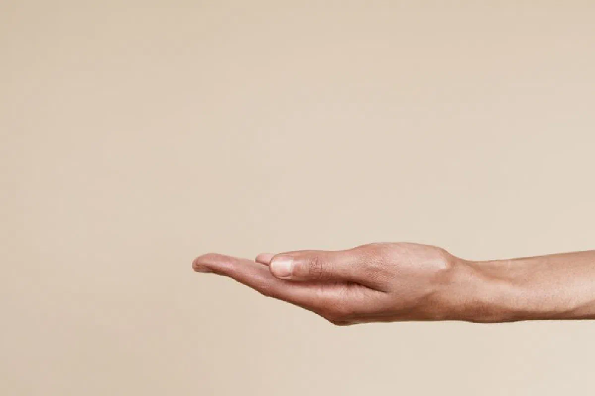 Close-up of an open hand reaching out isolated on a neutral background, symbolizing offering or receiving.