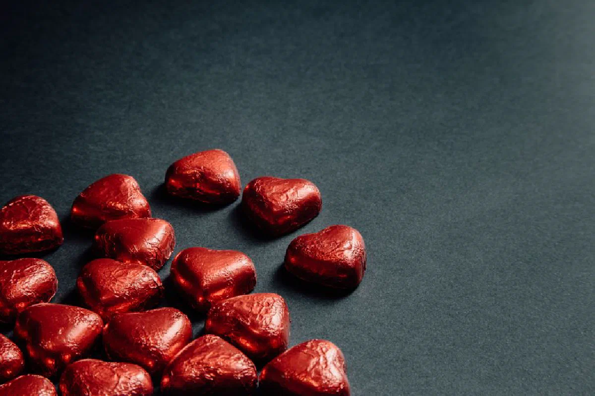 Heart-shaped red chocolates on a gray surface, perfect for romantic themes.