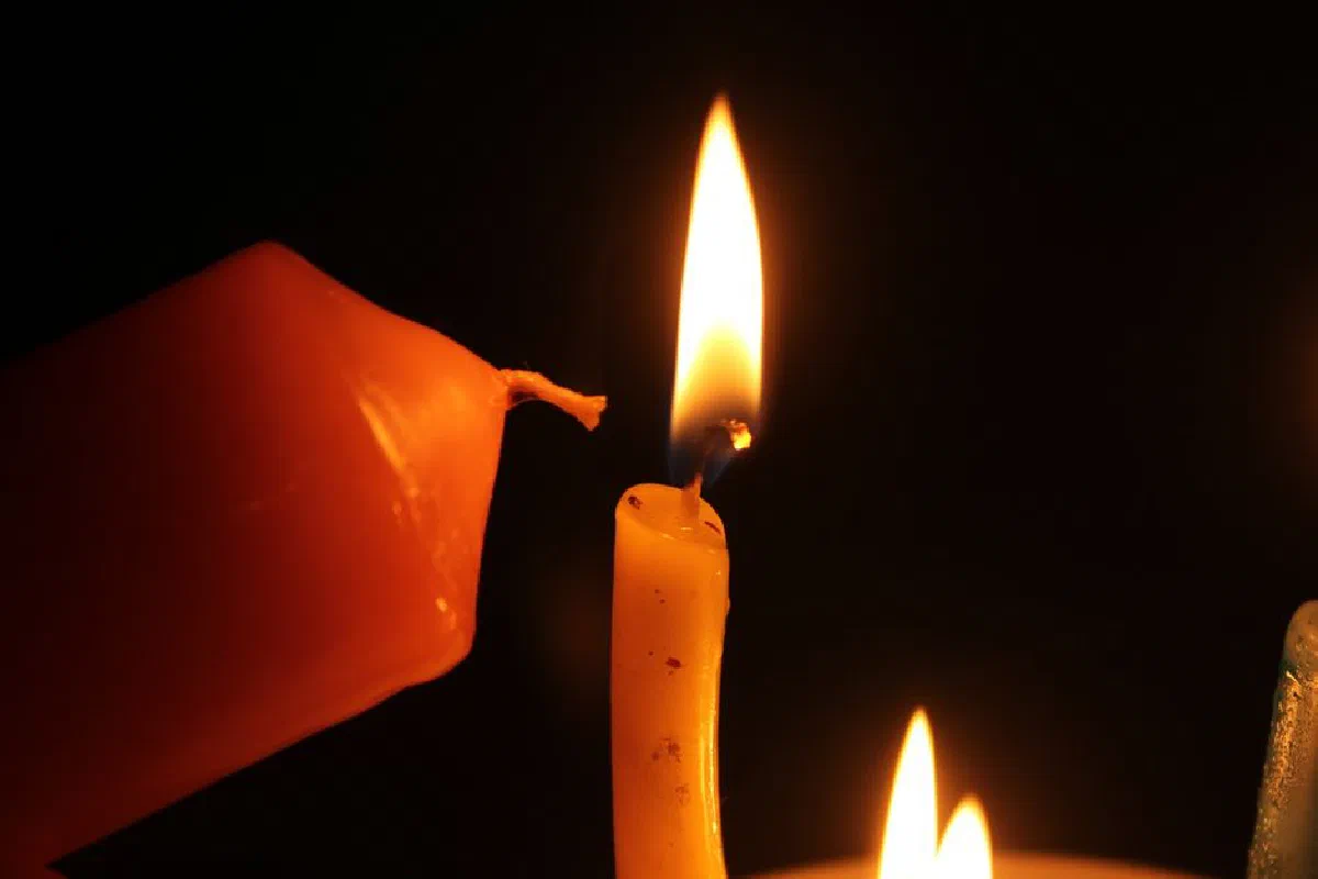 A close-up shot of candles burning in the dark, creating a warm and serene atmosphere.
