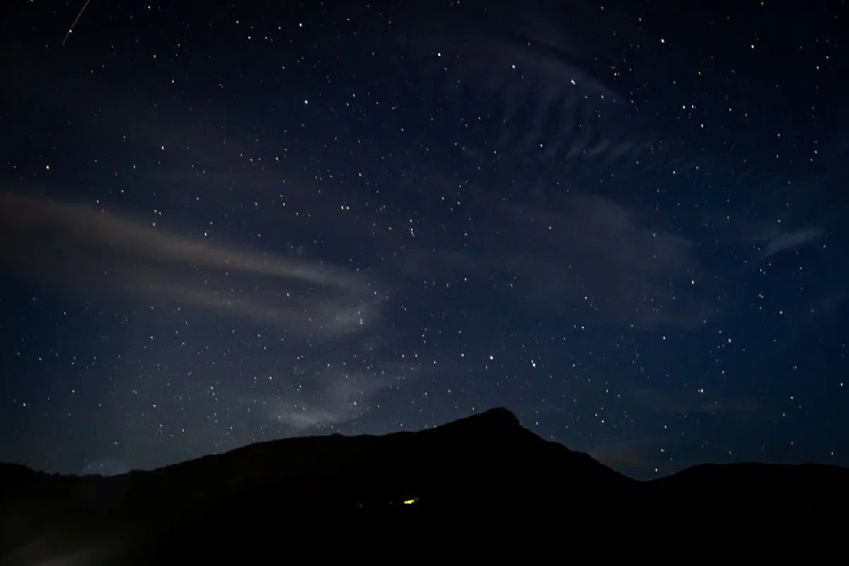 Beautiful star-filled night sky over a mountain silhouette, perfect for serene and cosmic themes.