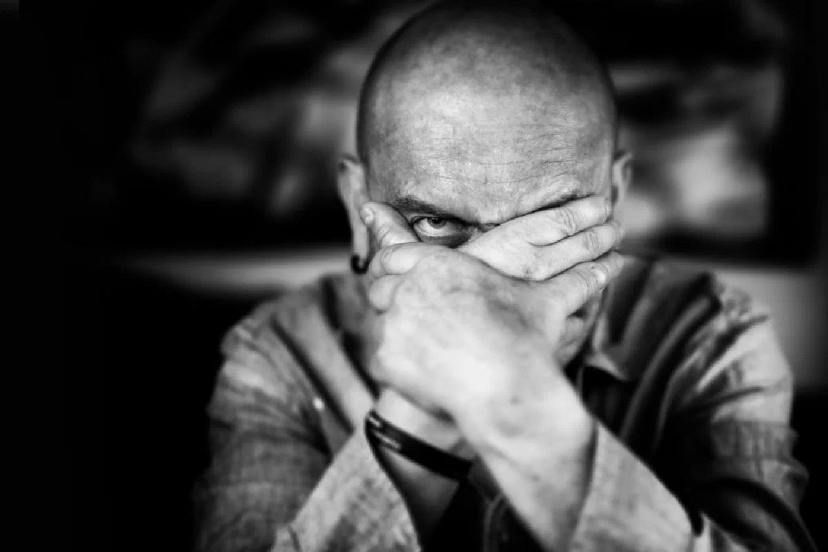Intriguing portrait of a man with hands covering face, creating a mysterious vibe.