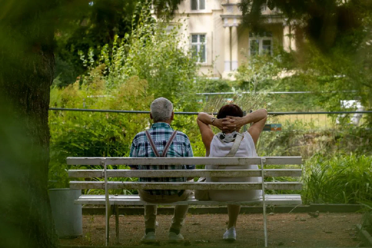 Senior couple enjoying a tranquil moment on a park bench surrounded by greenery in Nordhausen.