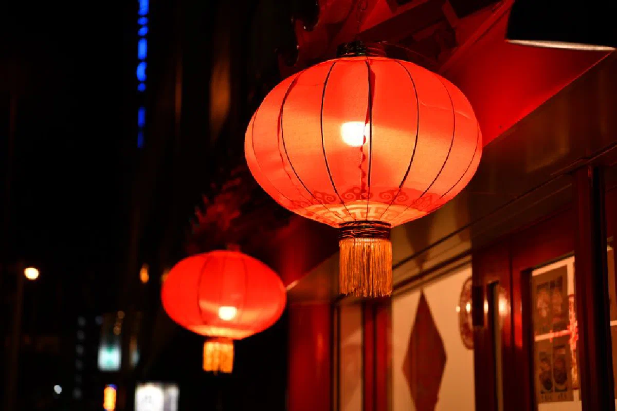 Vibrant red paper lanterns glowing at night in Osaka, Japan's street ambiance.