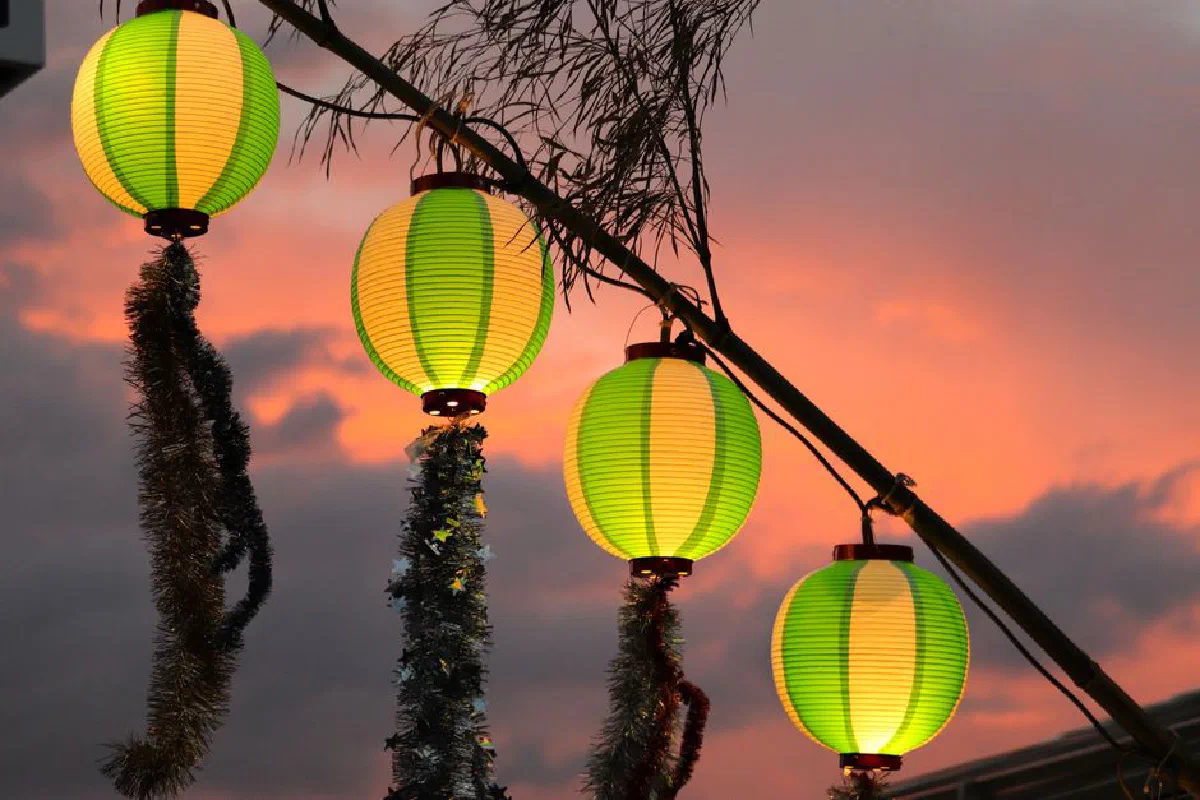 Colorful lanterns glowing against a sunset sky, creating a vibrant outdoor ambiance.