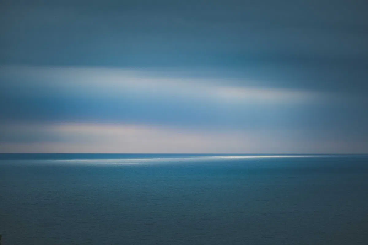A serene and expansive view of the calm ocean at twilight, capturing the peacefulness of nature.