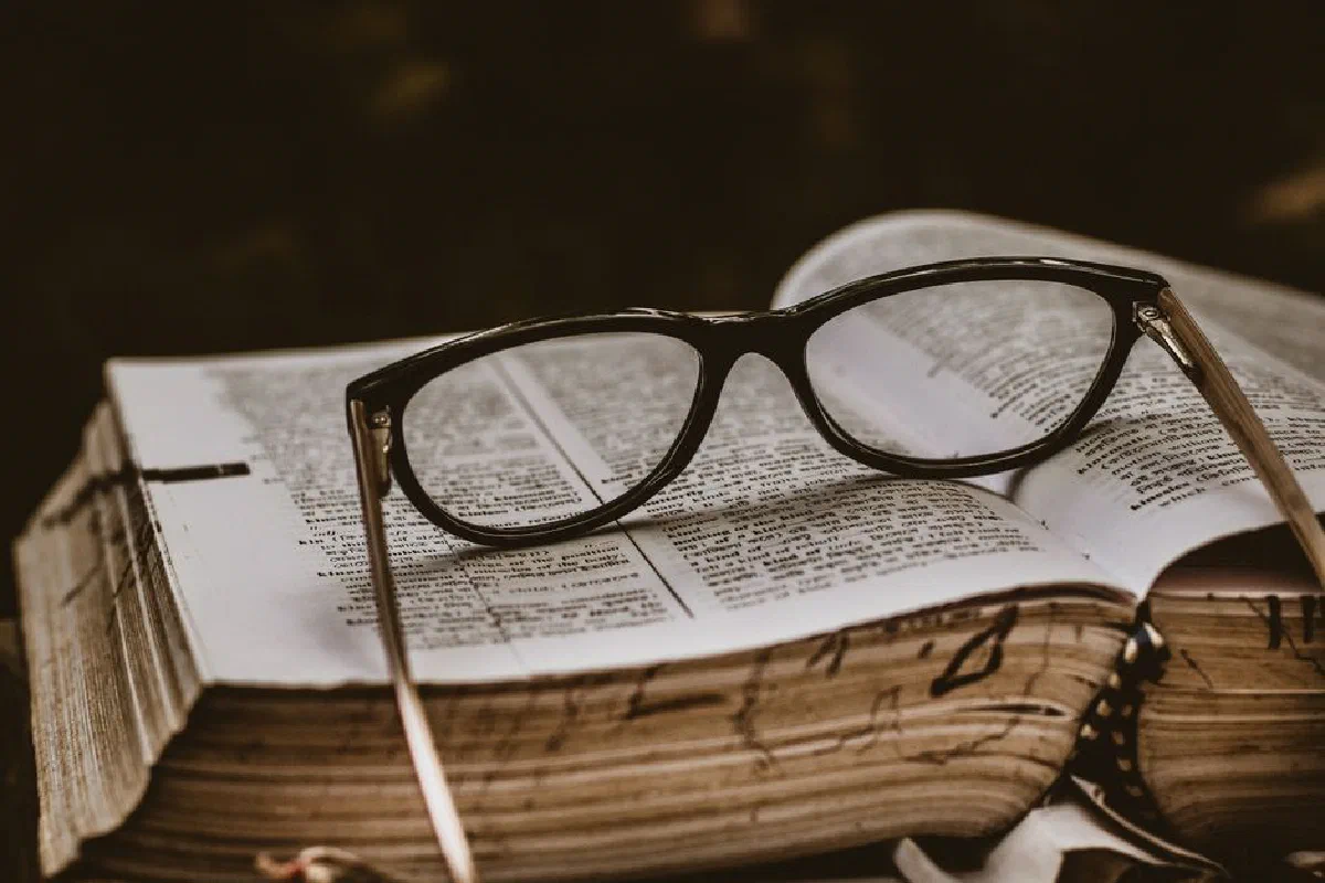 Close-up of eyeglasses on an open book, symbolizing study and knowledge.