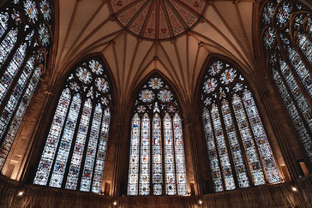 Majestic view of stained glass windows and vaulted ceiling in a gothic cathedral in York, UK.