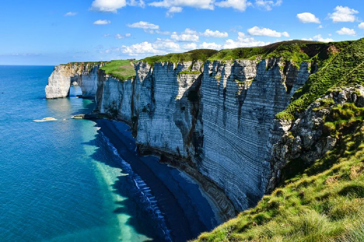 Explore the stunning cliffs of Étretat in Normandy with sweeping views over the sea and sky.