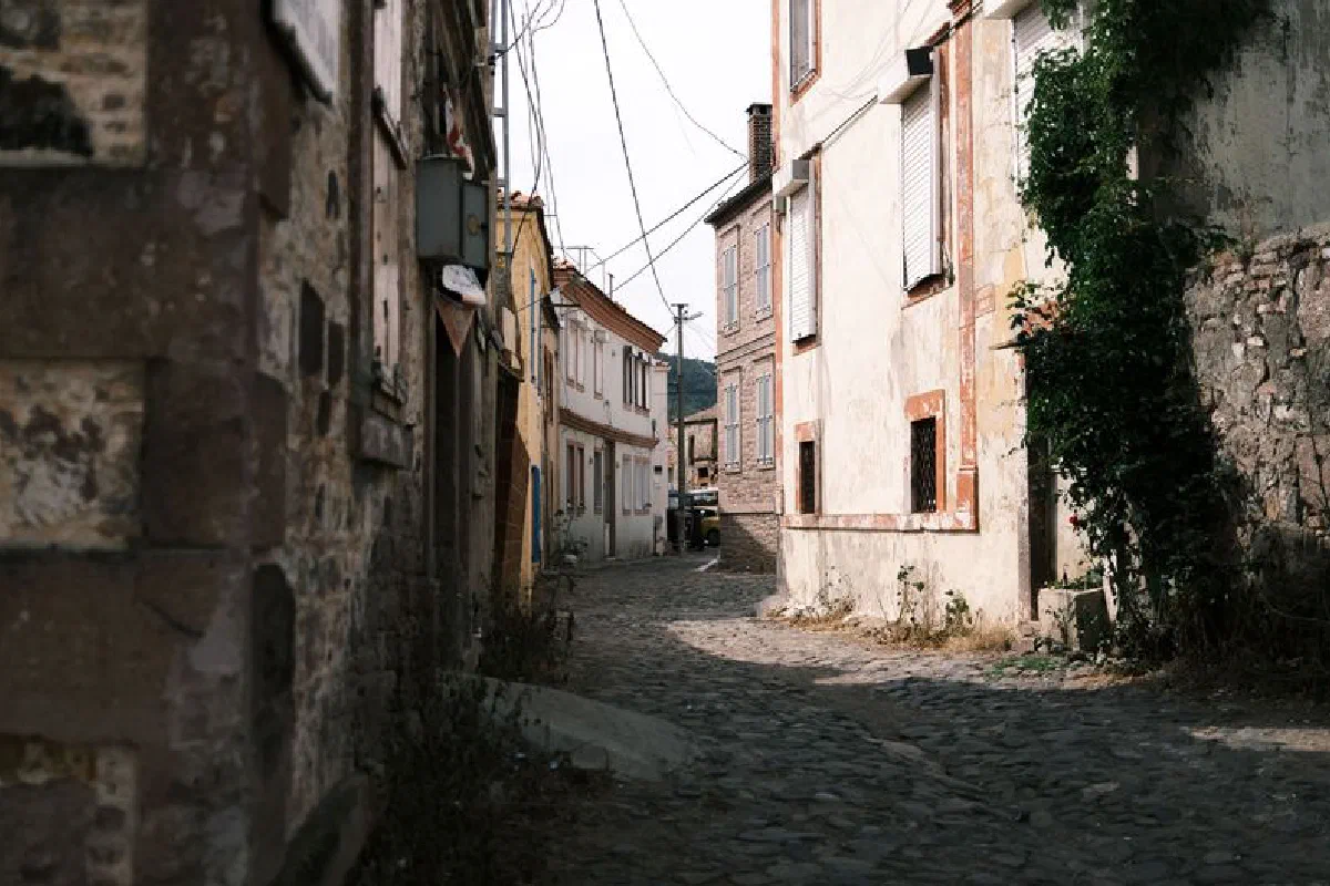 Charming cobblestone alley surrounded by rustic buildings in a historic old town setting.