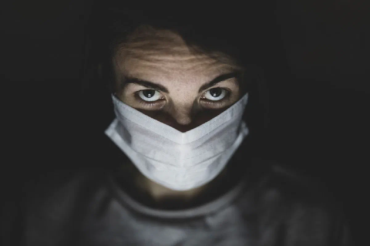 Close-up portrait of a person wearing a mask, emphasizing health and safety precautions.