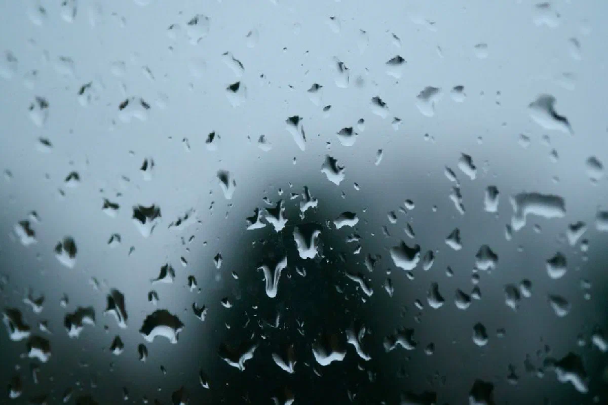 Close-up of raindrops on a window, creating a moody and serene ambiance.