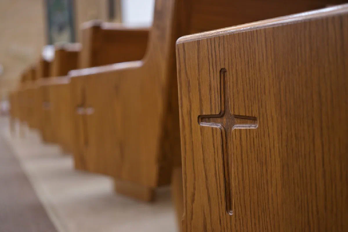 Detailed view of wooden church pews with cross carvings in a Berlin, Wisconsin church.