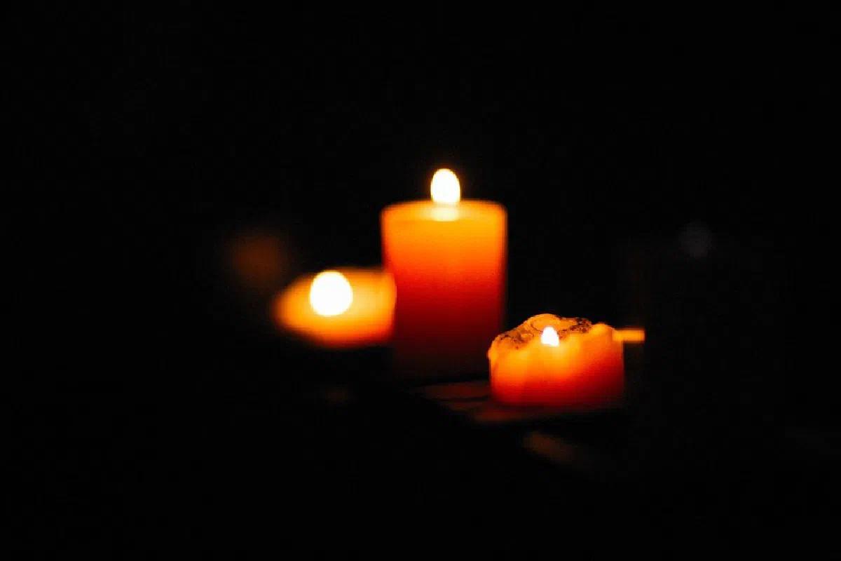 Close-up view of warmly lit candles creating a serene and peaceful ambiance in darkness.