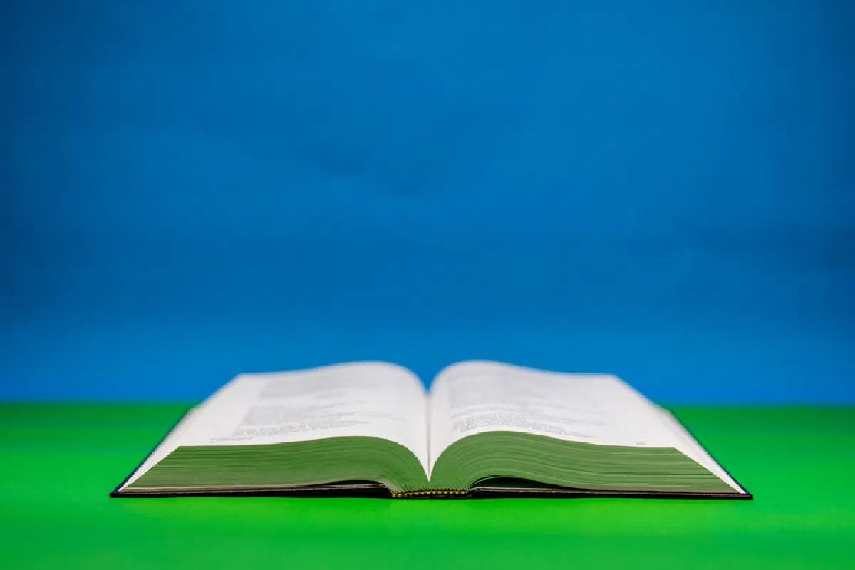 An open Bible on a vibrant green and blue backdrop symbolizing peace and spirituality.