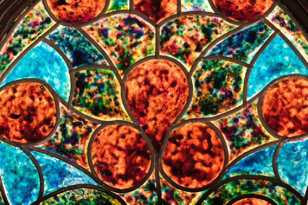 Colorful stained glass window with intricate floral patterns and vivid colors.