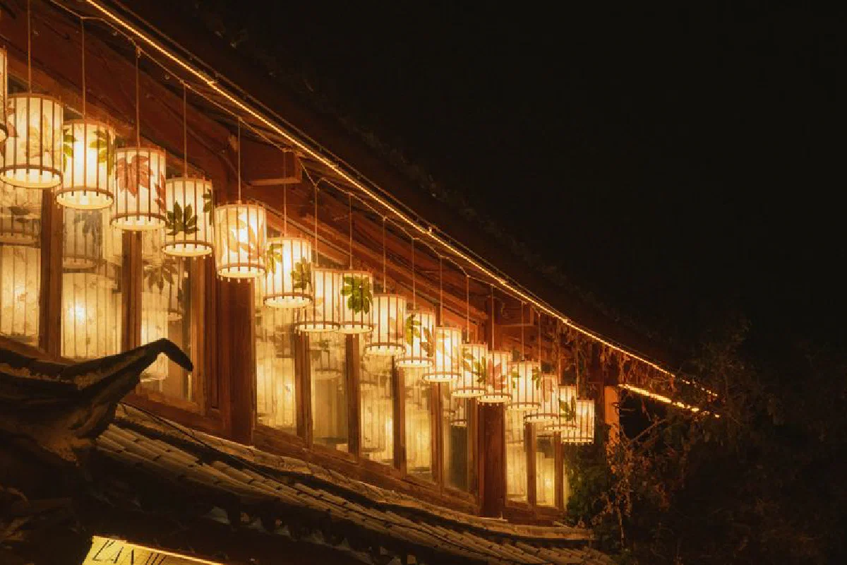 A serene display of traditional lanterns illuminating a rustic rooftop under the night sky.