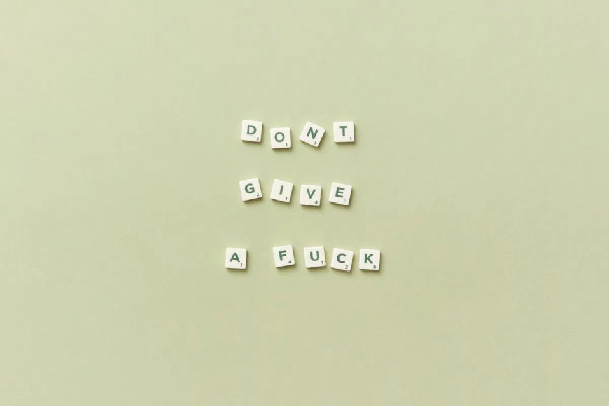 Scrabble tiles spelling a bold motivational phrase on a green background.
