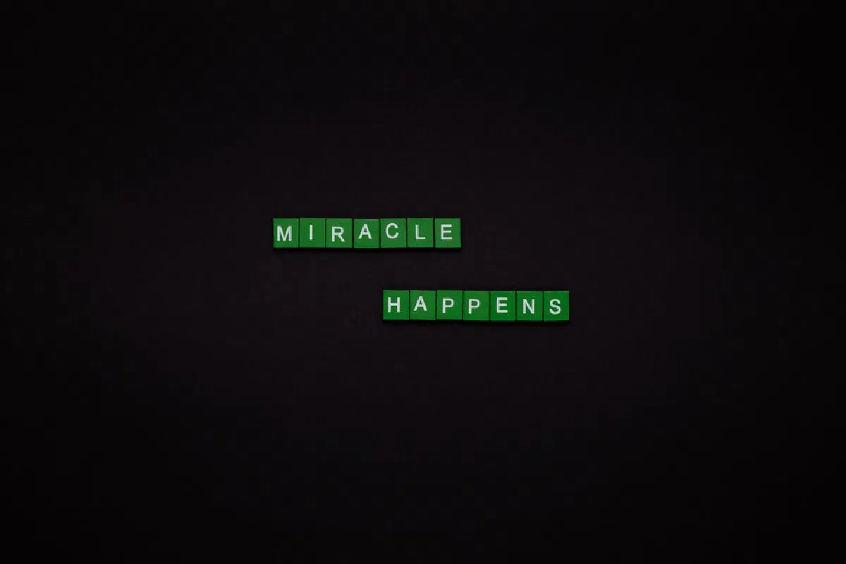 Motivational image featuring the words 'Miracle Happens' using green tiles on a black backdrop.
