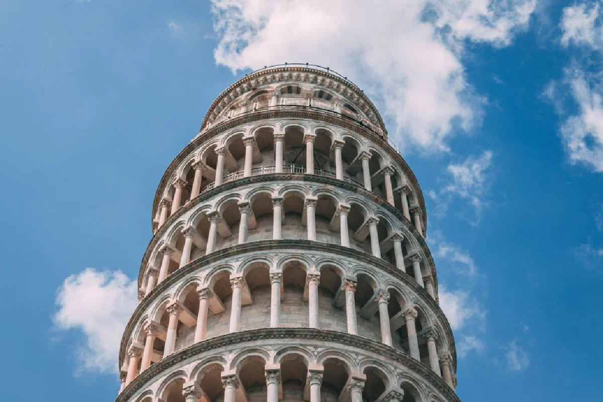 Low angle view of the iconic Leaning Tower of Pisa with a clear blue sky in the background.